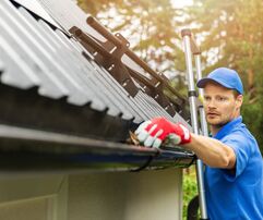 man repairing seamless gutters on house in the Miramar florida area